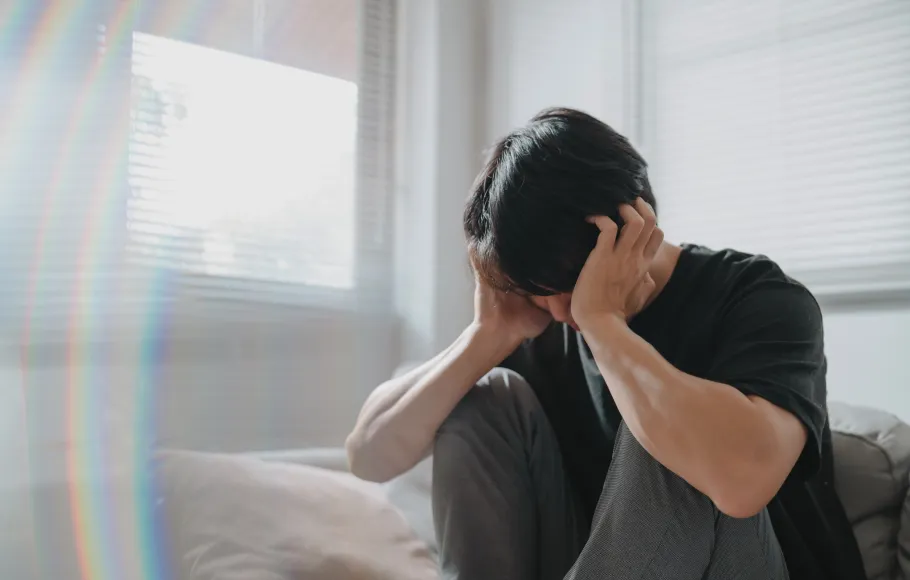 Tonårig pojke håller händerna för huvudet