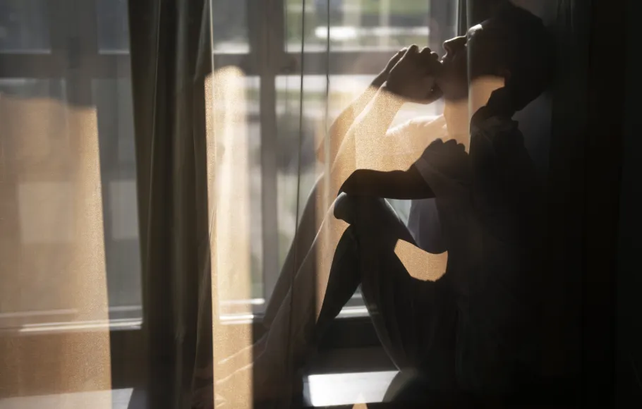 man som sitter bakom gardin