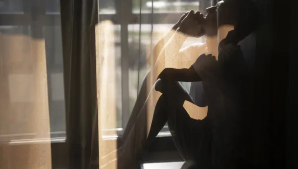 man som sitter bakom gardin