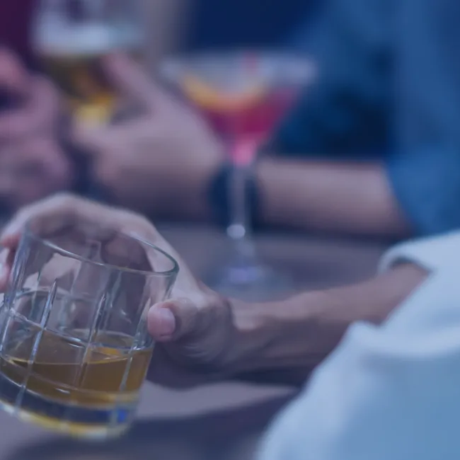 Man i bar med skjorta och whiskey